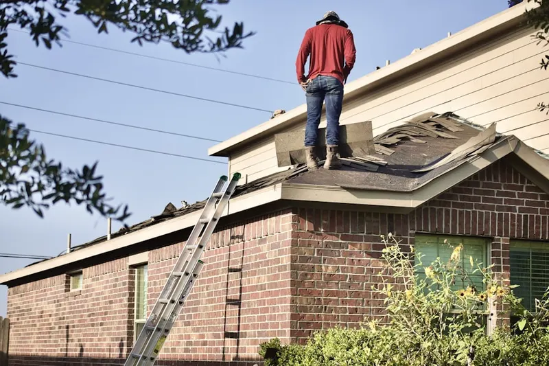 Professional roofer working on a residential roof in Little Neck